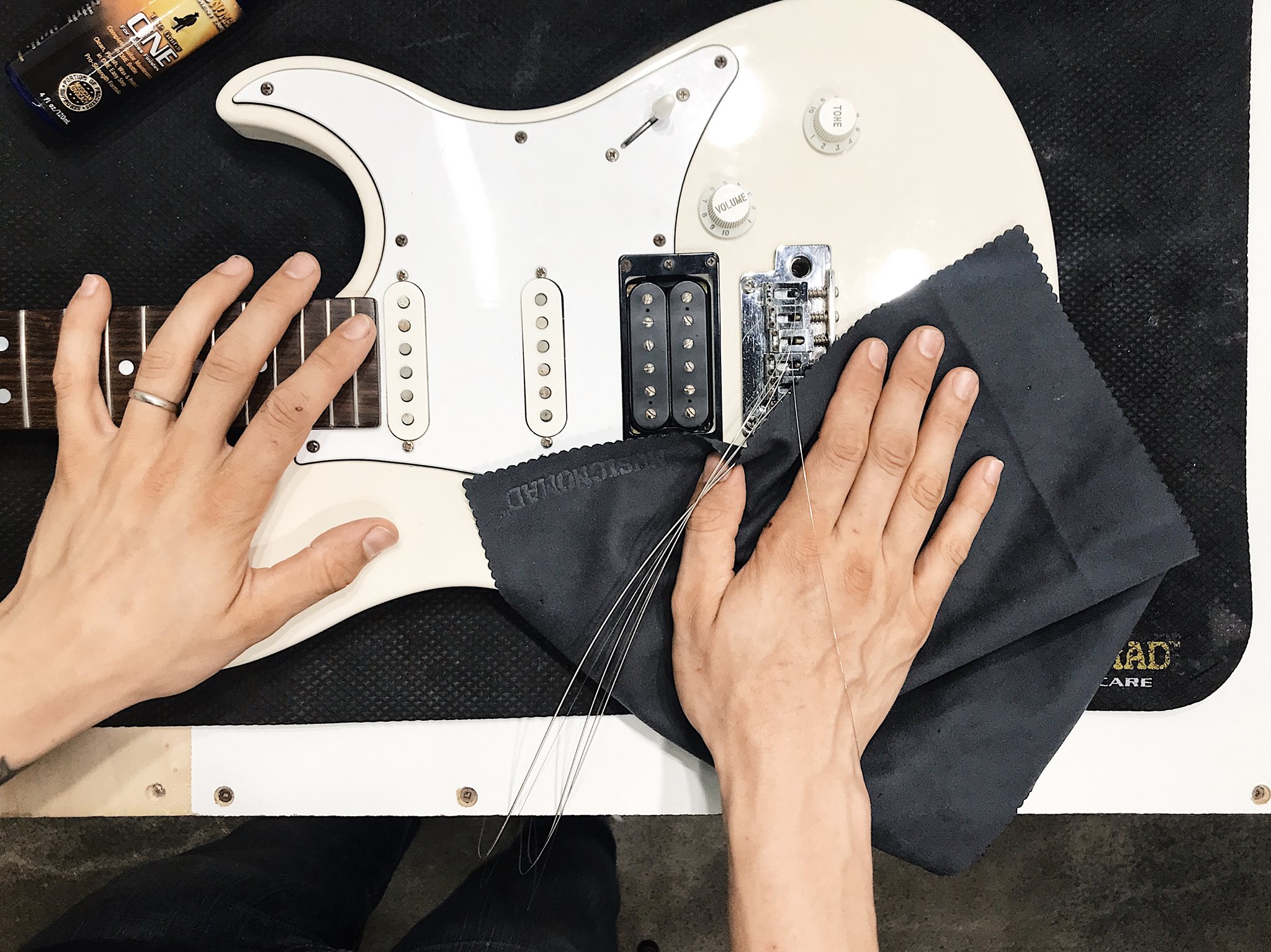 Hands working on a guitar setup